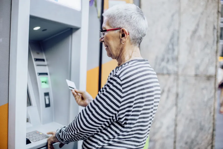 Ältere Frau am Bankomat