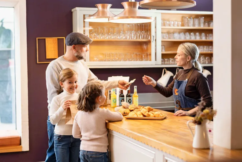 Vater mit zwei Kindern kauft in Bäckerei ein
