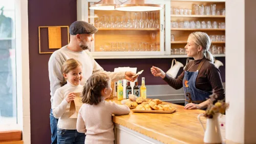 Vater mit zwei Kindern kauft in Bäckerei ein