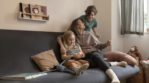 Mutter mit Kindern auf Polstergruppe